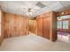 Bedroom with carpet flooring, wood paneling, and closet, offering ample space and storage solutions at 504 Gilliam St, Wildwood, FL 34785
