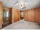 Wood-paneled bedroom featuring ceiling fan, closet, and access to another room at 504 Gilliam St, Wildwood, FL 34785