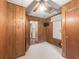 Wood-paneled bedroom featuring a ceiling fan, a television, and views into other rooms at 504 Gilliam St, Wildwood, FL 34785