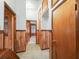 Hallway with wood paneling, built-in cabinets, and carpeted floor, offering a glimpse into a bedroom through an open doorway at 504 Gilliam St, Wildwood, FL 34785