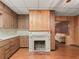 Cozy kitchen featuring classic wood cabinets, white appliances, and a decorative fireplace at 504 Gilliam St, Wildwood, FL 34785
