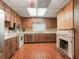 Charming kitchen features wood cabinets, stainless steel appliances, and a cozy fireplace for a unique touch at 504 Gilliam St, Wildwood, FL 34785