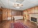 Living room featuring wood-paneled walls, hardwood floors, and fireplace at 504 Gilliam St, Wildwood, FL 34785