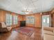 Living room featuring wood-paneled walls, hardwood floors, and shuttered windows at 504 Gilliam St, Wildwood, FL 34785