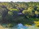 Aerial shot showcasing a house among lush trees and serene lily pad filled pond at 54544 Buckhorn Rd, Astor, FL 32102