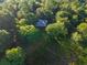 Aerial view of house nestled within a dense forest, bathed in sunlight at 54544 Buckhorn Rd, Astor, FL 32102
