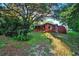 Cozy red home surrounded by lush greenery and mature trees, offering a serene setting at 54544 Buckhorn Rd, Astor, FL 32102