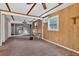 Spacious living room featuring wood-look walls, beamed ceiling, and ample natural light at 54544 Buckhorn Rd, Astor, FL 32102