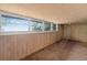 Bright living room features wood-paneled walls and multiple windows that enhance natural lighting at 54544 Buckhorn Rd, Astor, FL 32102