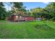 Rear exterior view of a cozy home with a spacious yard, and a separate shed for storage at 54544 Buckhorn Rd, Astor, FL 32102