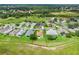 An aerial view of a single-Gathering home with a well-maintained yard in a serene community surrounded by lush greenery at 5715 Illumination Ln, Leesburg, FL 34748