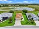 Aerial view of home featuring a well-maintained lawn, beautiful landscaping, and a peaceful pond in the background at 5715 Illumination Ln, Leesburg, FL 34748