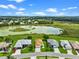 Beautiful aerial view of a home with a well-manicured lawn and lush greenery, set against the backdrop of a scenic pond at 5715 Illumination Ln, Leesburg, FL 34748