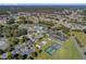 Aerial view displaying the community clubhouse, pool, tennis courts, and surrounding landscape at 5715 Illumination Ln, Leesburg, FL 34748