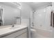 Standard bathroom showcasing a toilet, shower with curtain, sink and mirror, and tiled walls at 5715 Illumination Ln, Leesburg, FL 34748