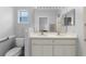 Bathroom featuring double vanity with white cabinets and a large mirror at 5715 Illumination Ln, Leesburg, FL 34748