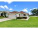 Charming single-story home with a well-manicured lawn and attached garage, near a scenic lake at 5715 Illumination Ln, Leesburg, FL 34748