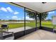 Screened lanai offering serene lake views, a grill, and an inviting outdoor atmosphere at 5715 Illumination Ln, Leesburg, FL 34748