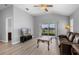 Bright living room featuring sleek floors, modern ceiling fan and scenic views through sliding glass doors at 5715 Illumination Ln, Leesburg, FL 34748