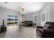 Cozy living area with hardwood floors, modern fan, and sliding doors providing natural light at 5715 Illumination Ln, Leesburg, FL 34748