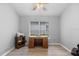 Neutral home office with a classic wooden desk, printer station, and ample natural light at 5715 Illumination Ln, Leesburg, FL 34748