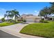 Charming house featuring a three-car garage and a well-manicured lawn at 5740 Bounty Cir, Tavares, FL 32778