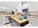 Bright kitchen with stainless appliances, kitchen island, white cabinets, and natural light at 5740 Bounty Cir, Tavares, FL 32778