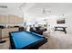 Open concept living room featuring a billiards table, comfortable seating, and natural lighting at 5740 Bounty Cir, Tavares, FL 32778