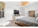 Bright main bedroom with ceiling fan, large window, television, and closet at 5740 Bounty Cir, Tavares, FL 32778