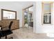 Carpeted office space featuring a dresser, mirror, and desk with a sliding glass door to the lanai at 5740 Bounty Cir, Tavares, FL 32778