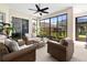 Inviting sunroom with large windows and comfortable wicker furniture at 5740 Bounty Cir, Tavares, FL 32778