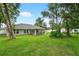 Spacious backyard with a covered patio, hot tub, mature trees, and lush lawn at 8160 Se 164Th Pl, Summerfield, FL 34491