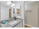 Bathroom featuring vanity with granite countertop, mirror and walk-in shower in background at 8160 Se 164Th Pl, Summerfield, FL 34491