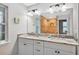 Bright bathroom featuring double sinks with granite countertop and shower with tiled wall at 8160 Se 164Th Pl, Summerfield, FL 34491