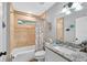 Bathroom featuring neutral colors, single vanity with granite countertop, and tub with shower at 8160 Se 164Th Pl, Summerfield, FL 34491