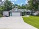 Single-story home featuring a spacious driveway, well-maintained lawn, and attached two-car garage at 8160 Se 164Th Pl, Summerfield, FL 34491