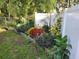 Beautiful garden bed with a mix of colorful plants and decorative fencing along the white fence at 8160 Se 164Th Pl, Summerfield, FL 34491