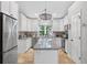 Well-lit kitchen featuring white cabinetry, stainless steel appliances, and a large granite island at 8160 Se 164Th Pl, Summerfield, FL 34491