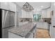 Spacious kitchen offers white cabinetry, granite counters, stainless appliances and a central island at 8160 Se 164Th Pl, Summerfield, FL 34491
