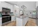 Charming kitchen features white cabinets, stainless appliances, granite counters and a large island at 8160 Se 164Th Pl, Summerfield, FL 34491