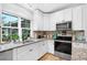 Bright kitchen offers stainless appliances, granite counters and tile flooring at 8160 Se 164Th Pl, Summerfield, FL 34491