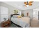 Calm and inviting bedroom with a comfortable bed, ceiling fan and natural light from the windows at 8160 Se 164Th Pl, Summerfield, FL 34491