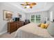 Bright bedroom with large window, woven dresser, cozy bed, ceiling fan, and art at 8160 Se 164Th Pl, Summerfield, FL 34491