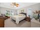 Comfortable bedroom with carpet, ceiling fan, windows with blinds and an inviting bed with decorative pillows at 8160 Se 164Th Pl, Summerfield, FL 34491