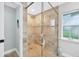 Walk-in shower featuring light brown tiled walls and glass partition with decorative starfish at 8160 Se 164Th Pl, Summerfield, FL 34491