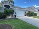 Home with green lawn and a two car garage with a concrete driveway at 15509 Markham Dr, Clermont, FL 34714