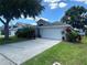 Home exterior showing the front entrance, driveway, and the two car garage at 15509 Markham Dr, Clermont, FL 34714