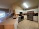 Kitchen featuring stainless steel appliances, white cabinets, and a peninsula island at 15509 Markham Dr, Clermont, FL 34714