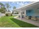 Covered back patio with outdoor seating and well-maintained lawn at 1025 Capella Dr, Tavares, FL 32778