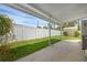 Backyard with a covered patio, white fence, and lush green lawn at 1025 Capella Dr, Tavares, FL 32778